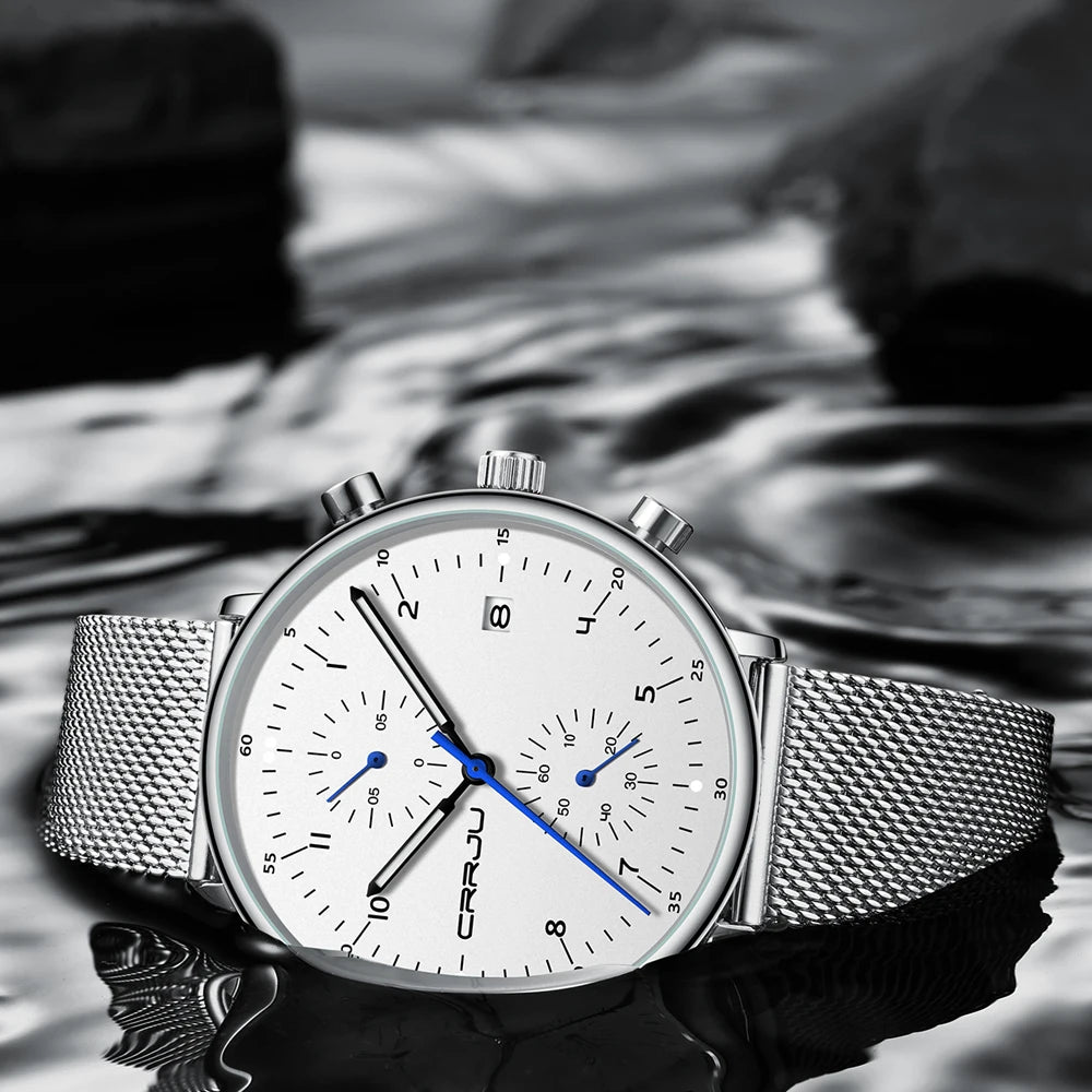 Silver watch with a white face on a blurred natural background