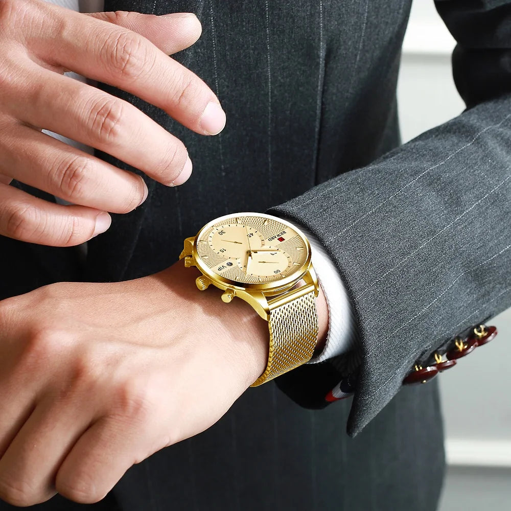 Gold wristwatch on a person's wrist with a suit background