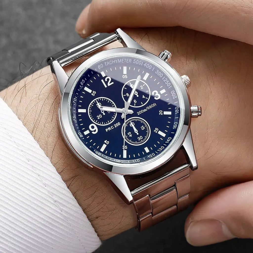 Close-up of a person wearing a silver watch with a blue face on a wrist.