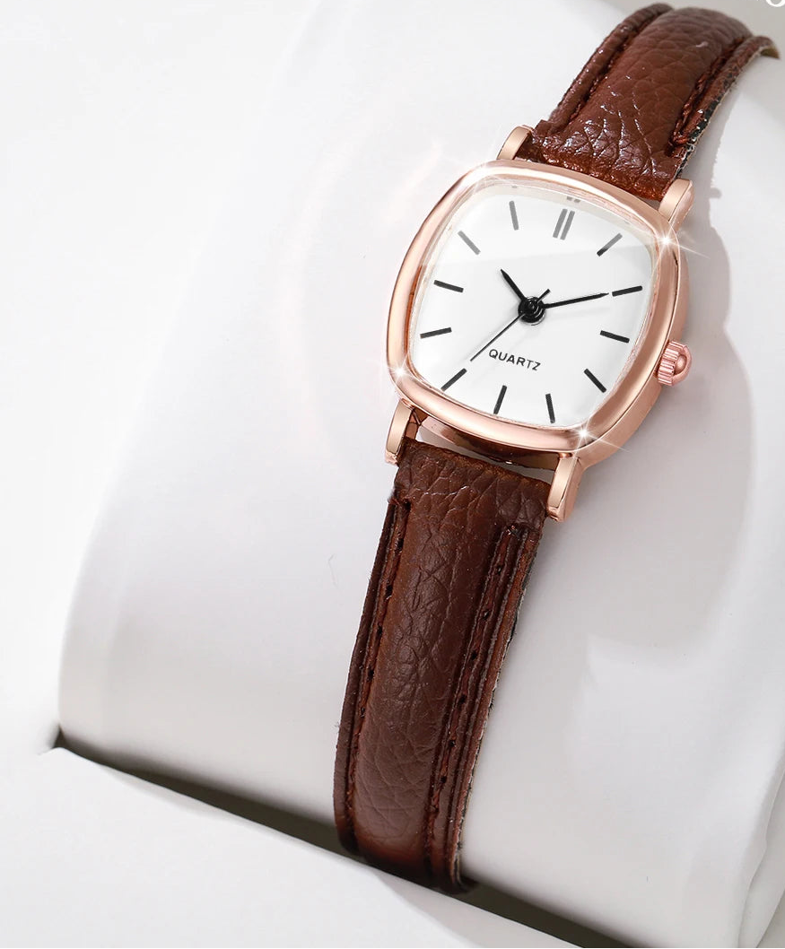 Wristwatch with brown leather strap and rose gold case on a white cushion