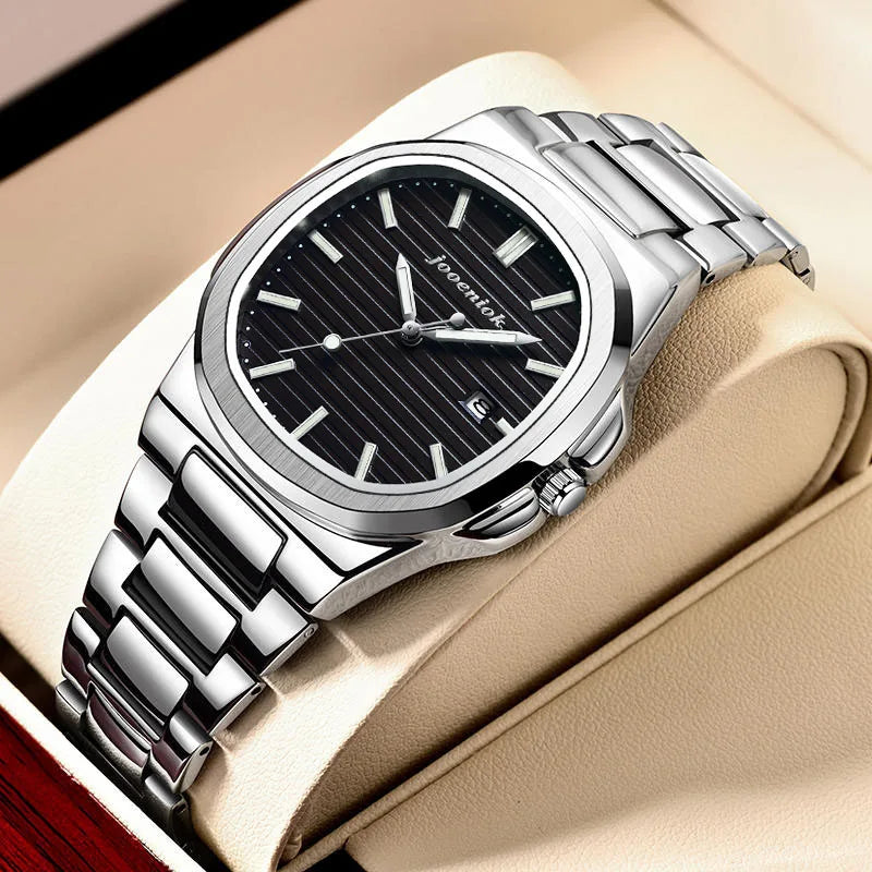 Silver watch with black dial on a beige cushion