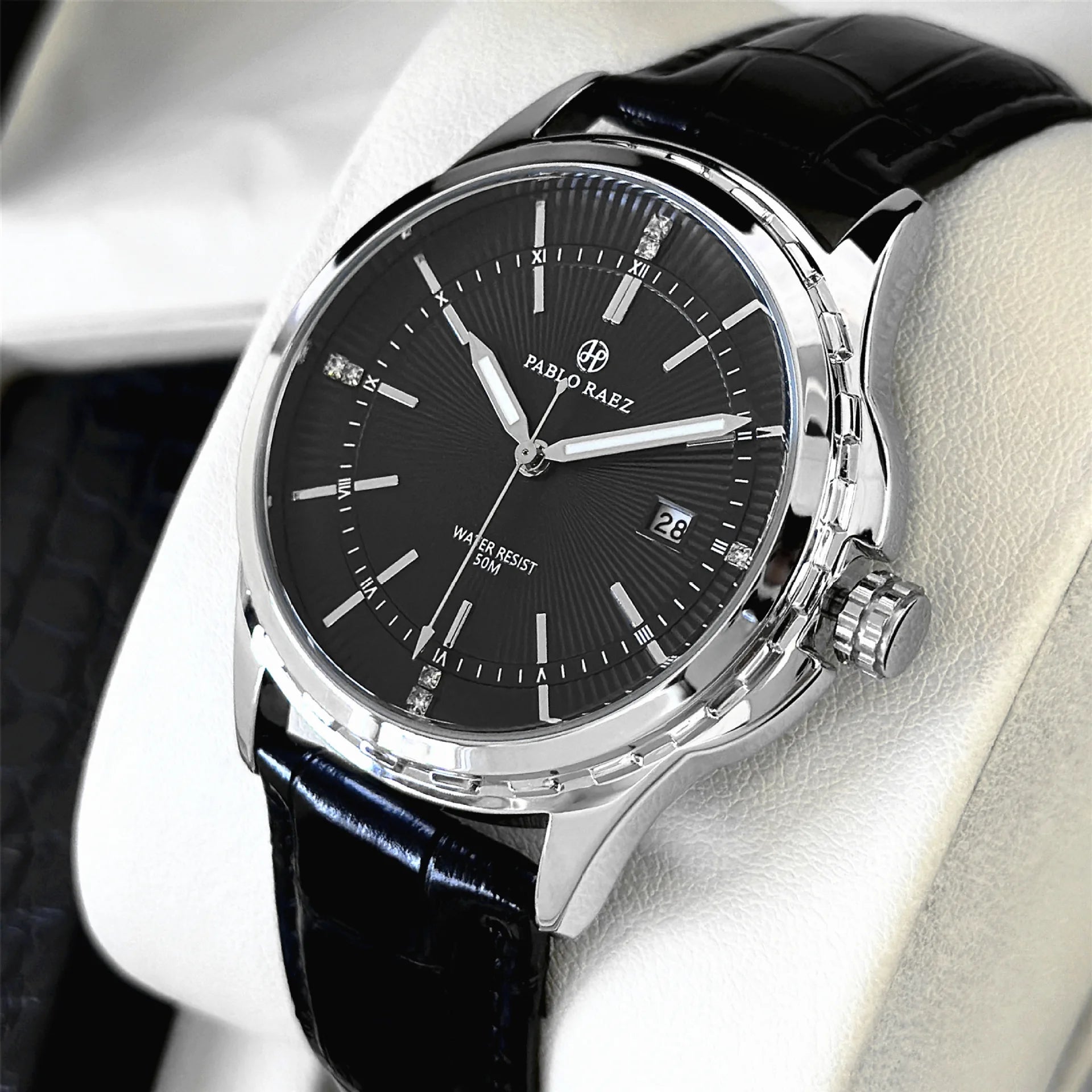Black wristwatch with silver case on a white surface