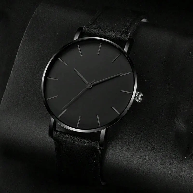 Black wristwatch with a leather strap on a dark background