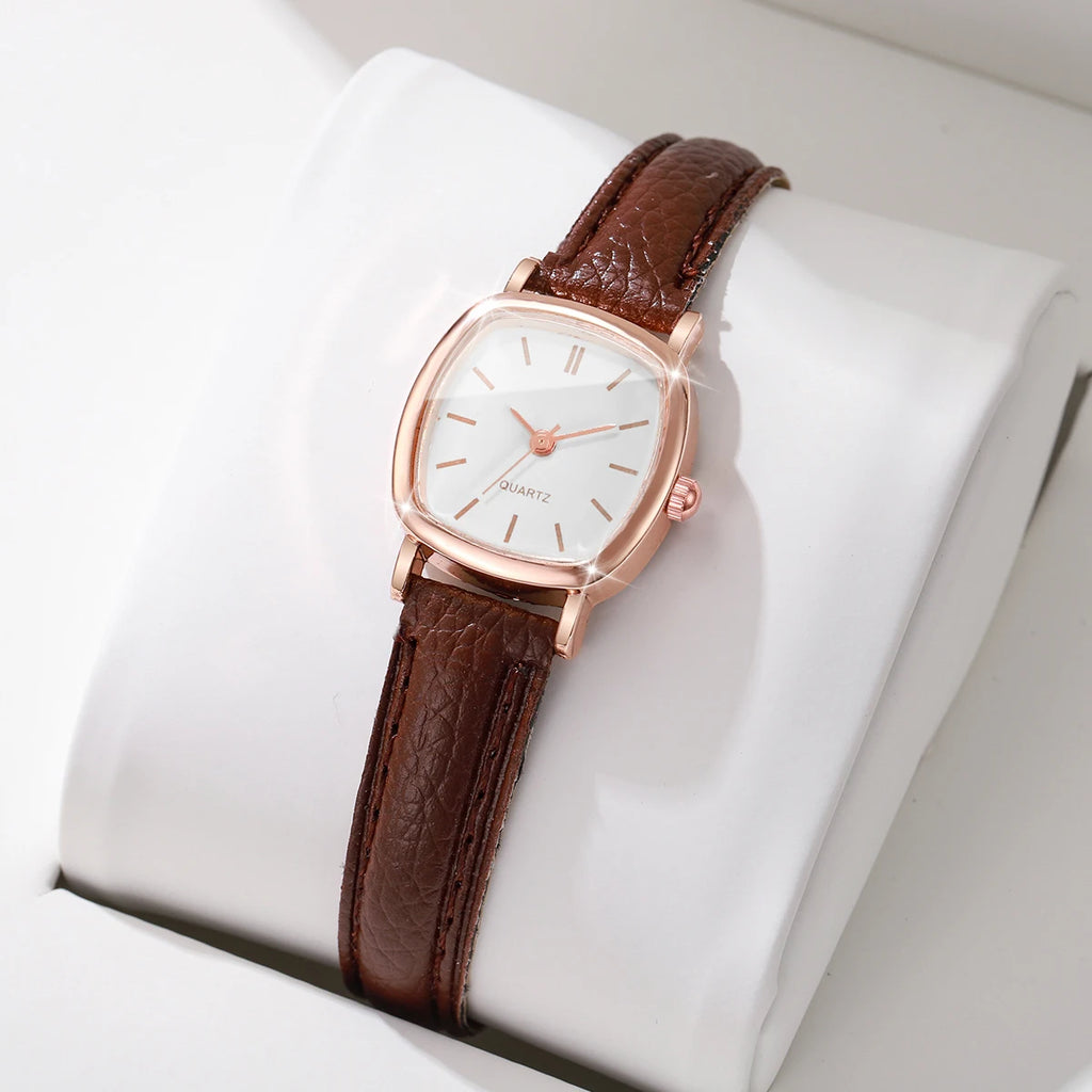 Wristwatch with brown leather strap and rose gold case on a white cushion