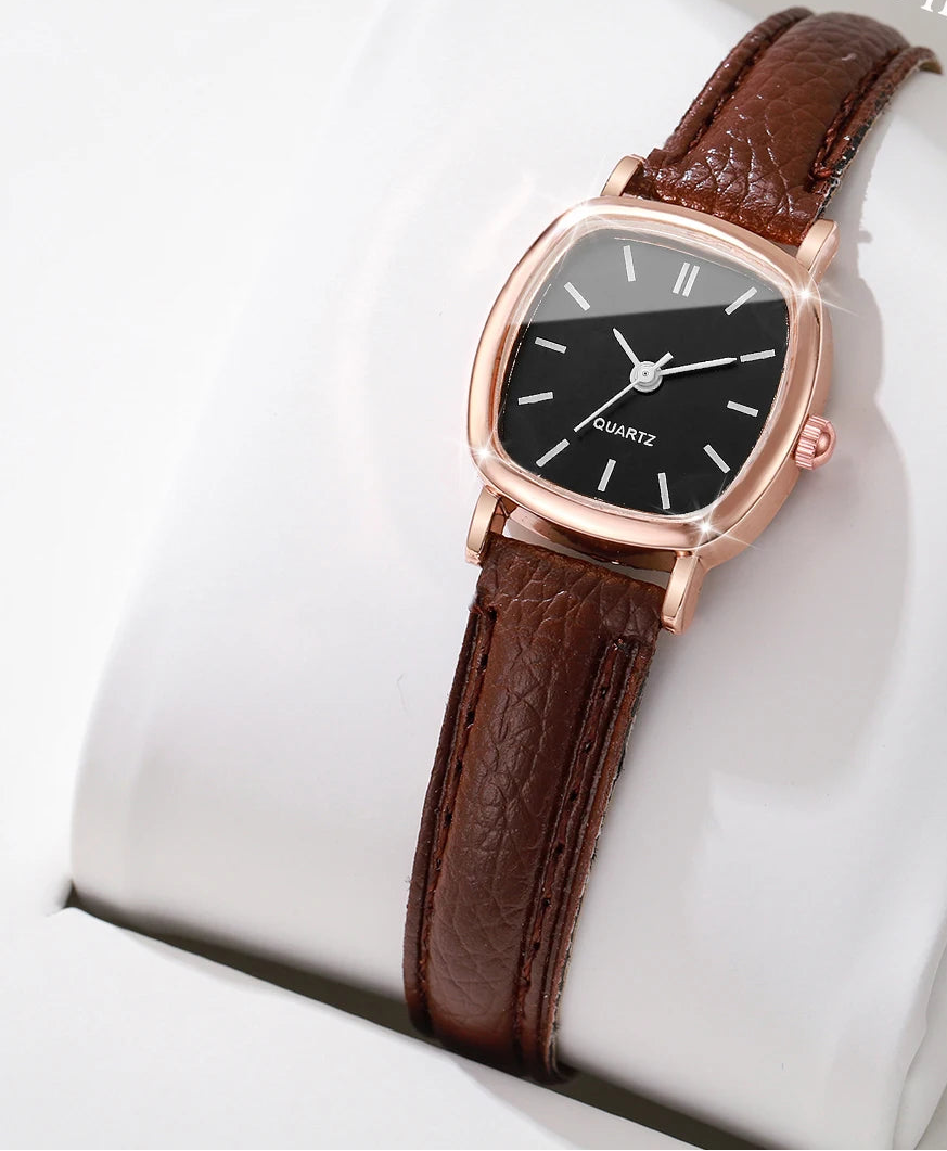 Wristwatch with brown leather strap and rose gold case on a white cushion